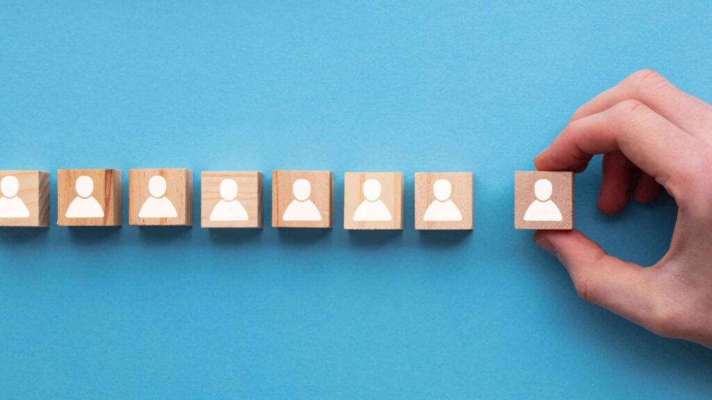 Wooden blocks with icons of people, showcasing a concept of recruitment or organisational hierarchy.