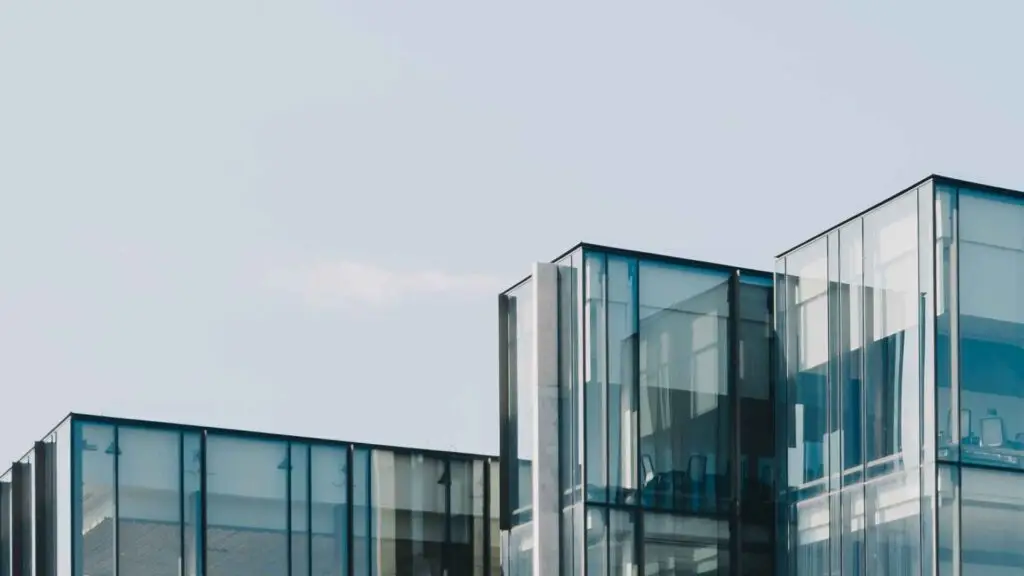 A close-up view of a contemporary office building featuring sleek glass panels and minimalist architecture against a clear sky.