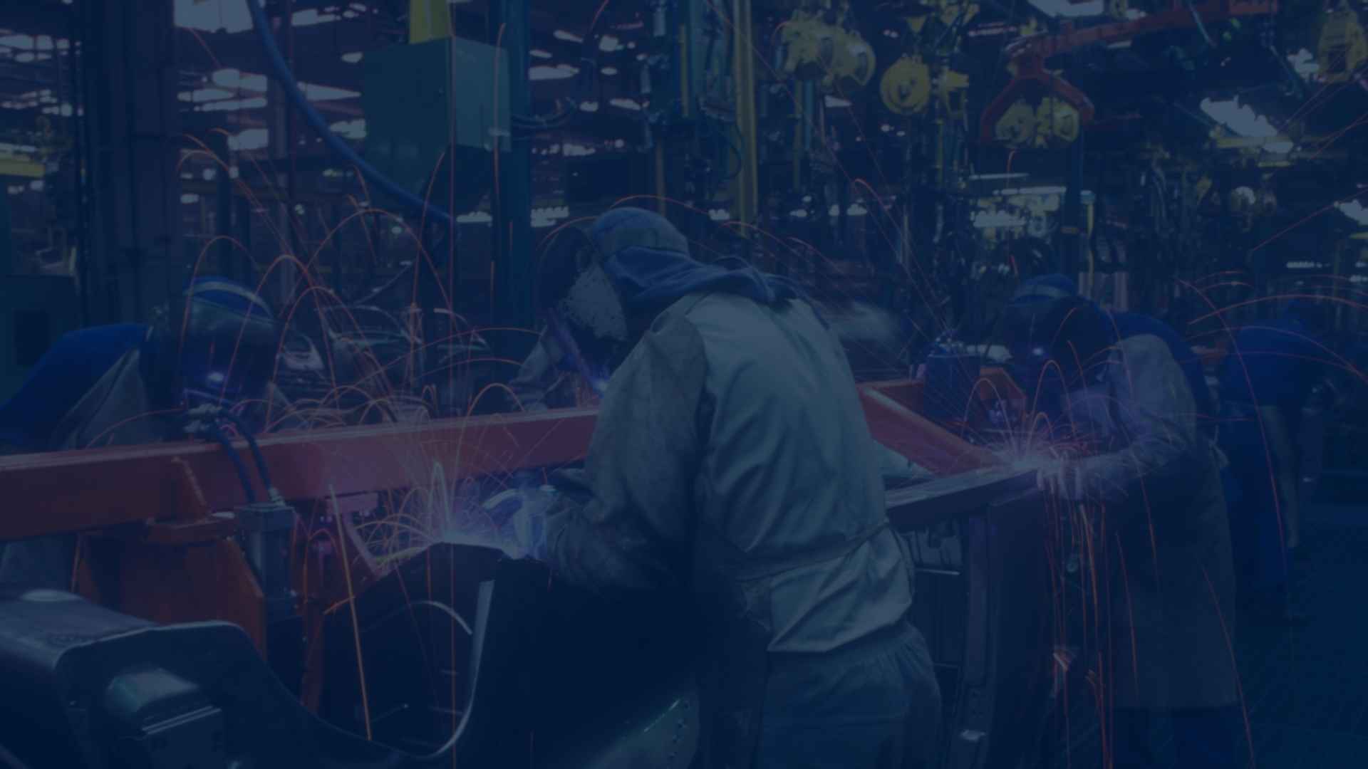 welders in protective gear performing welding tasks in a busy manufacturing facility.